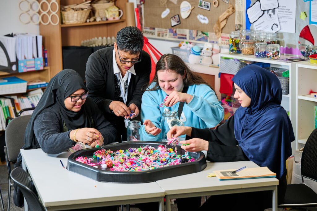 Childcare lecturer leading students in a craft activity