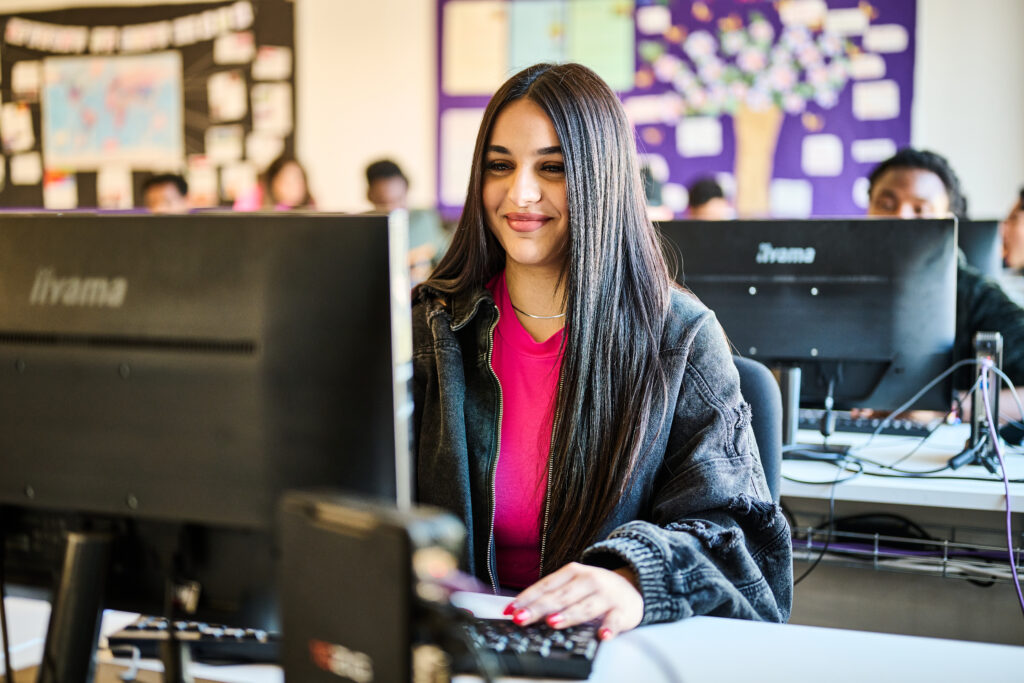 Girl smiling and working on her computer