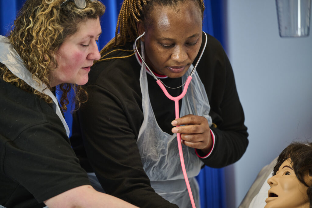 Teacher demonstrating to Health & Social Care student