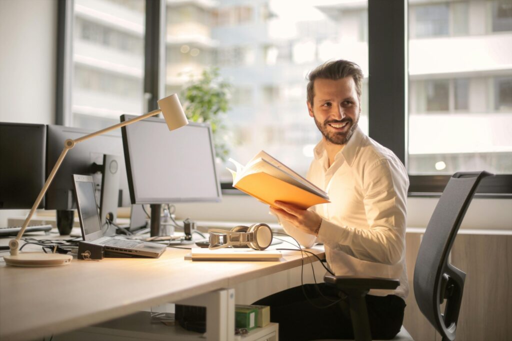Man smiling at his desk with a notebook