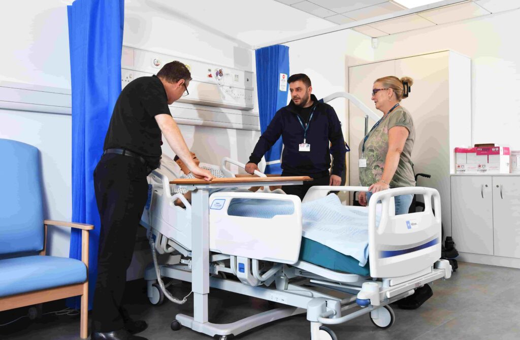 Cradley Heath lecturer teaching two adult students with hospital bed